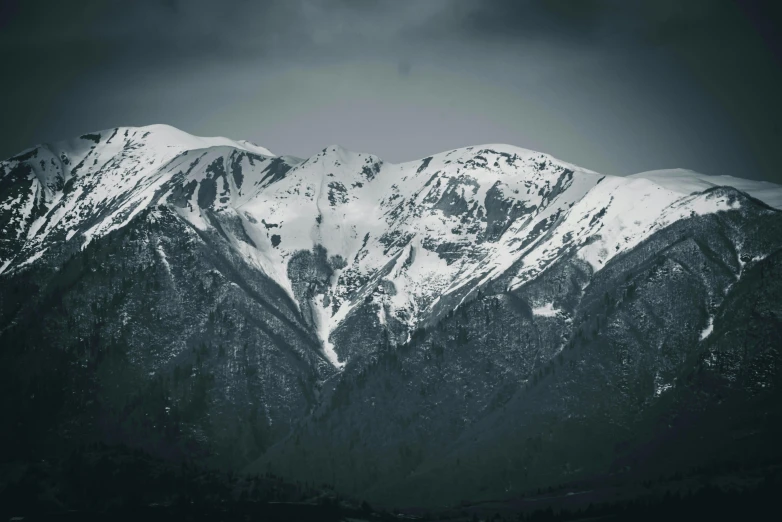 snowy mountains in the distance with one lone person standing in the foreground