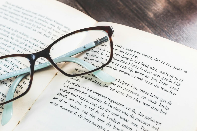 glasses resting on a book, with the book opened