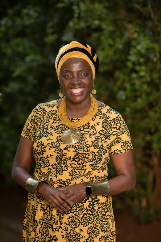 a woman wearing a yellow and black dress and smiling at the camera