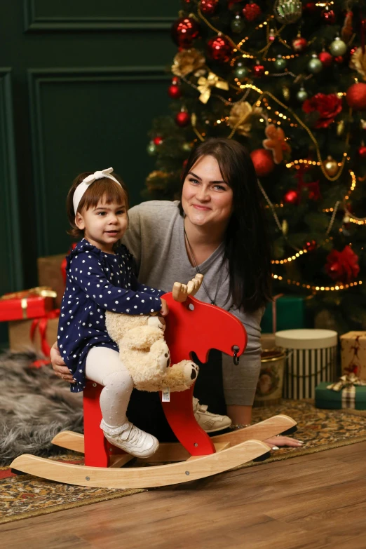 a small child and adult are posing next to a rocking horse