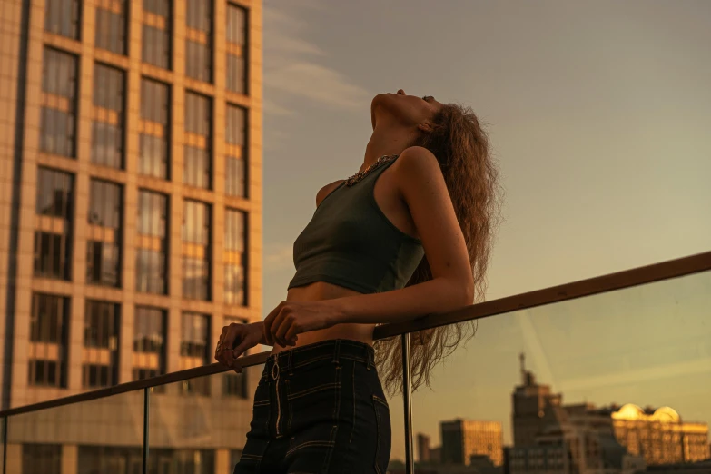 a girl on a balcony with buildings in the background