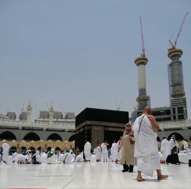 a crowd of people walking around a white courtyard