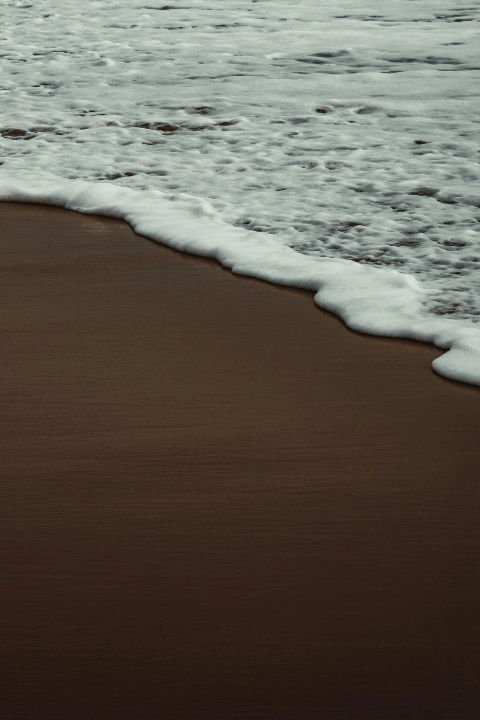 a man walking the beach with a surfboard