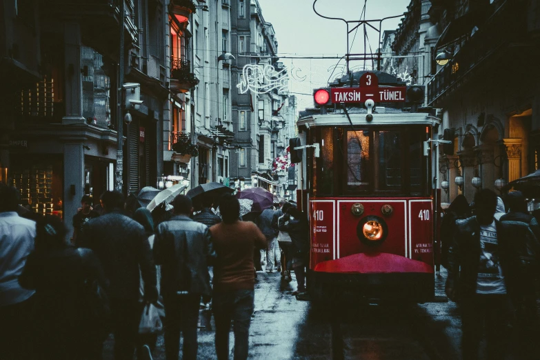 people are walking down the wet streets during the day