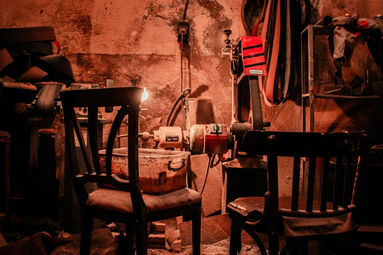 a dark room with several old wooden chairs and other furniture