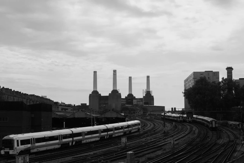 a train traveling through a city with smoke stacks