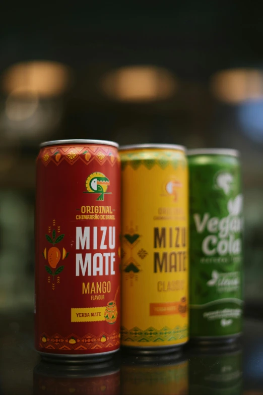 three different colored soda cans on a table