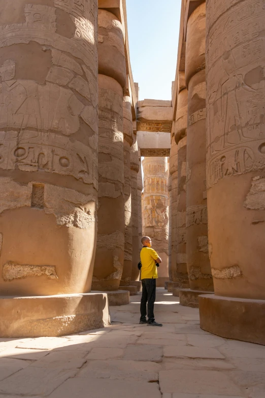 man standing by several ancient architecture in an open space