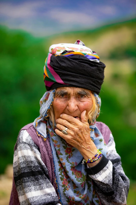 a woman wearing a colorful head covering and a ring