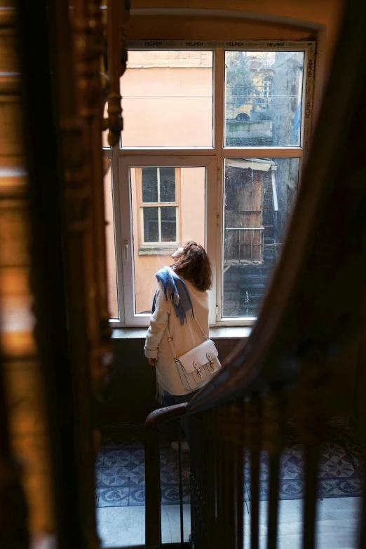 a person in white jacket sitting by window
