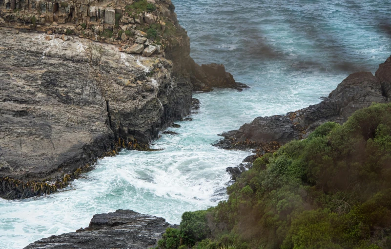 water going through a rocky coastline near the shoreline