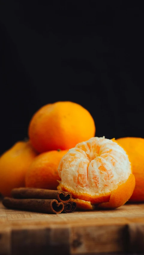 a pile of oranges sitting on top of a wooden  board