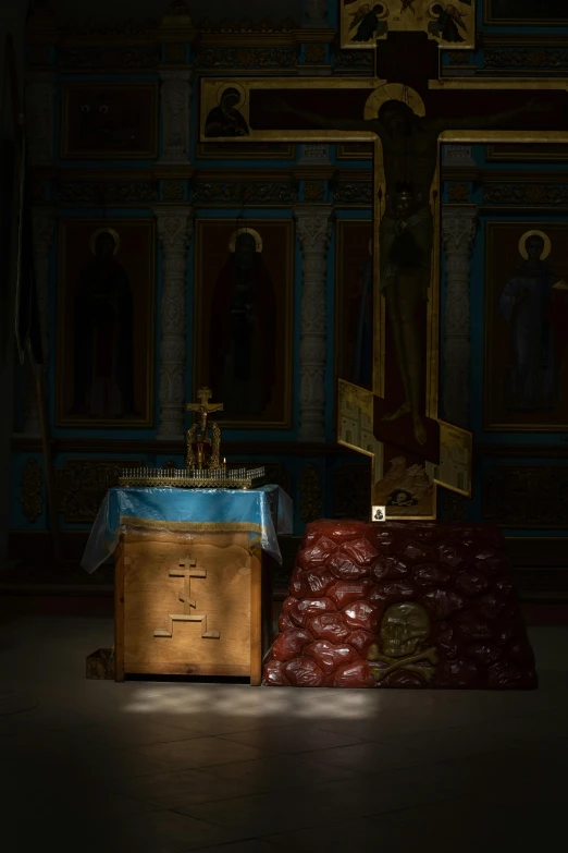 a altar in the center of a room with a cloth covering the floor and gold crosses