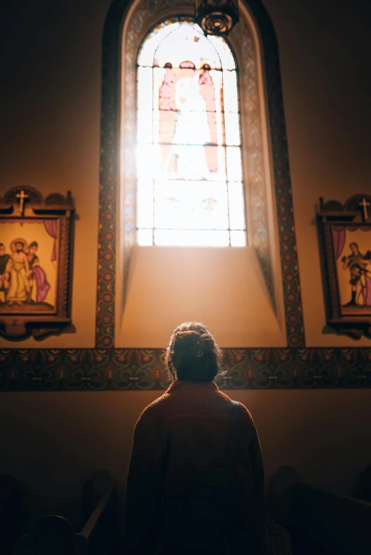 a woman looking up at a stained glass window