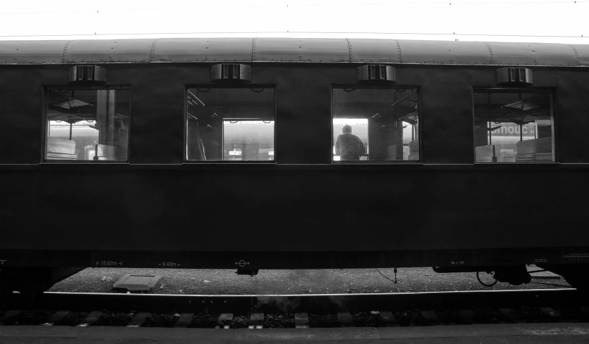 an old train sits at the station as passengers look out of their windows