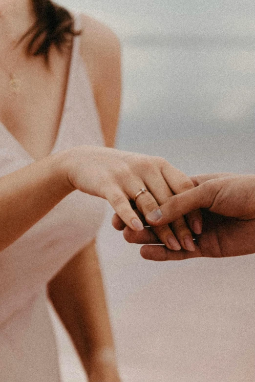 a woman holding the hand of an unrecogniized man in the background