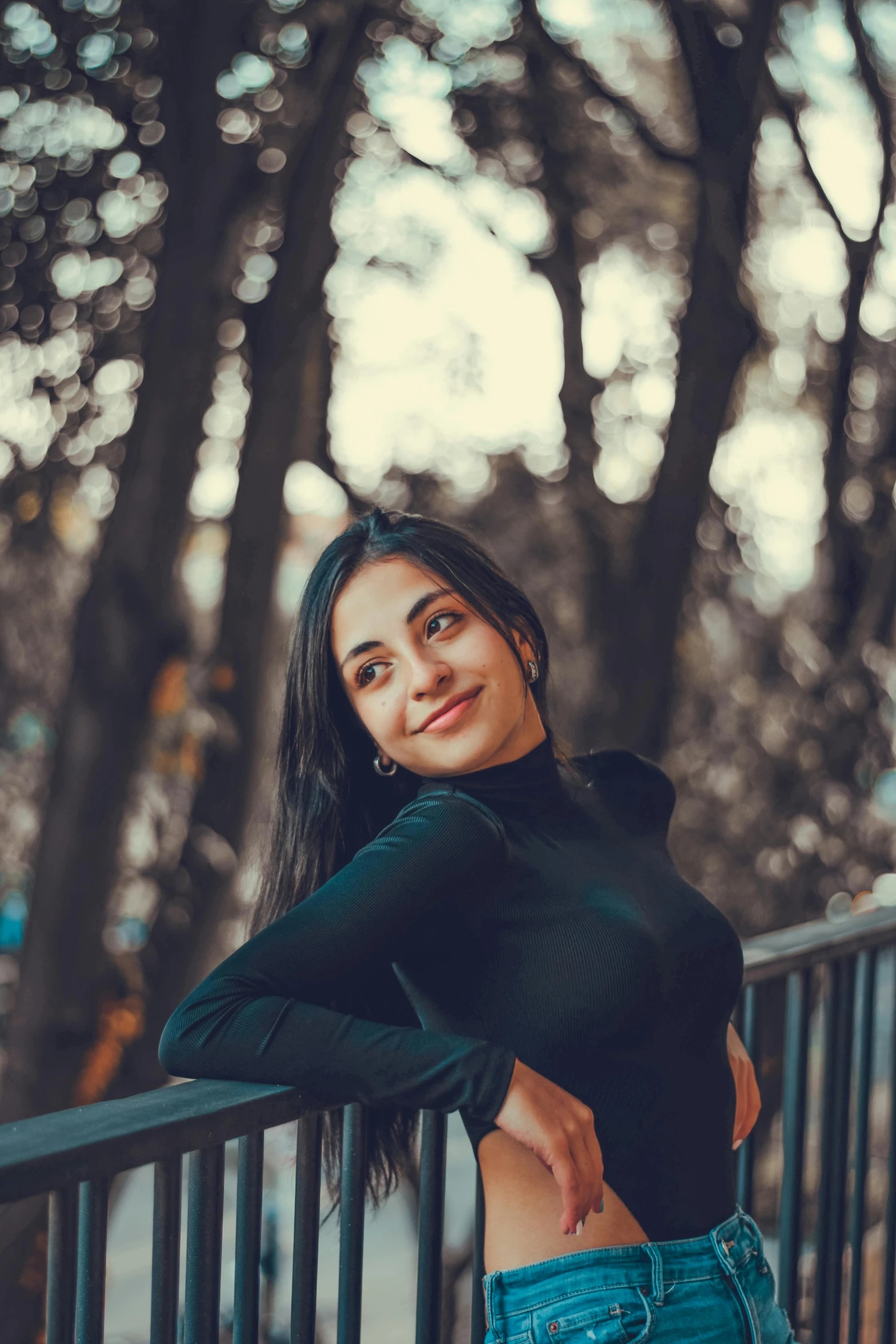 a woman in jean shorts and black shirt posing on railing