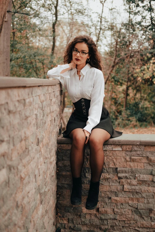 a woman wearing a white shirt and black skirt