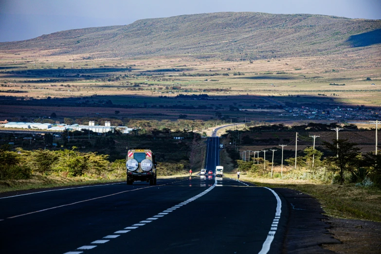 a man is driving down the empty road