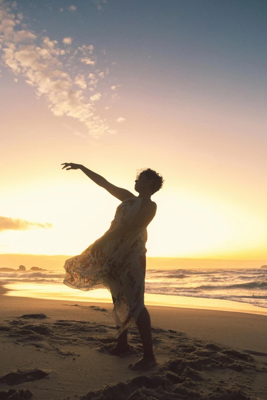 the woman is walking along the sand holding a surfboard