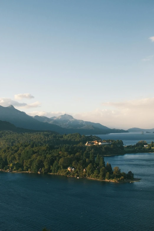 the mountains are behind an island on a lake