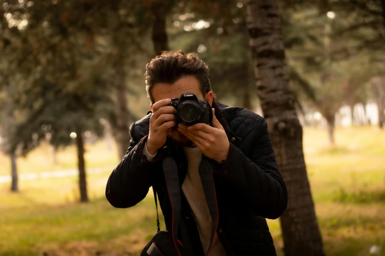 a man taking a po in front of trees