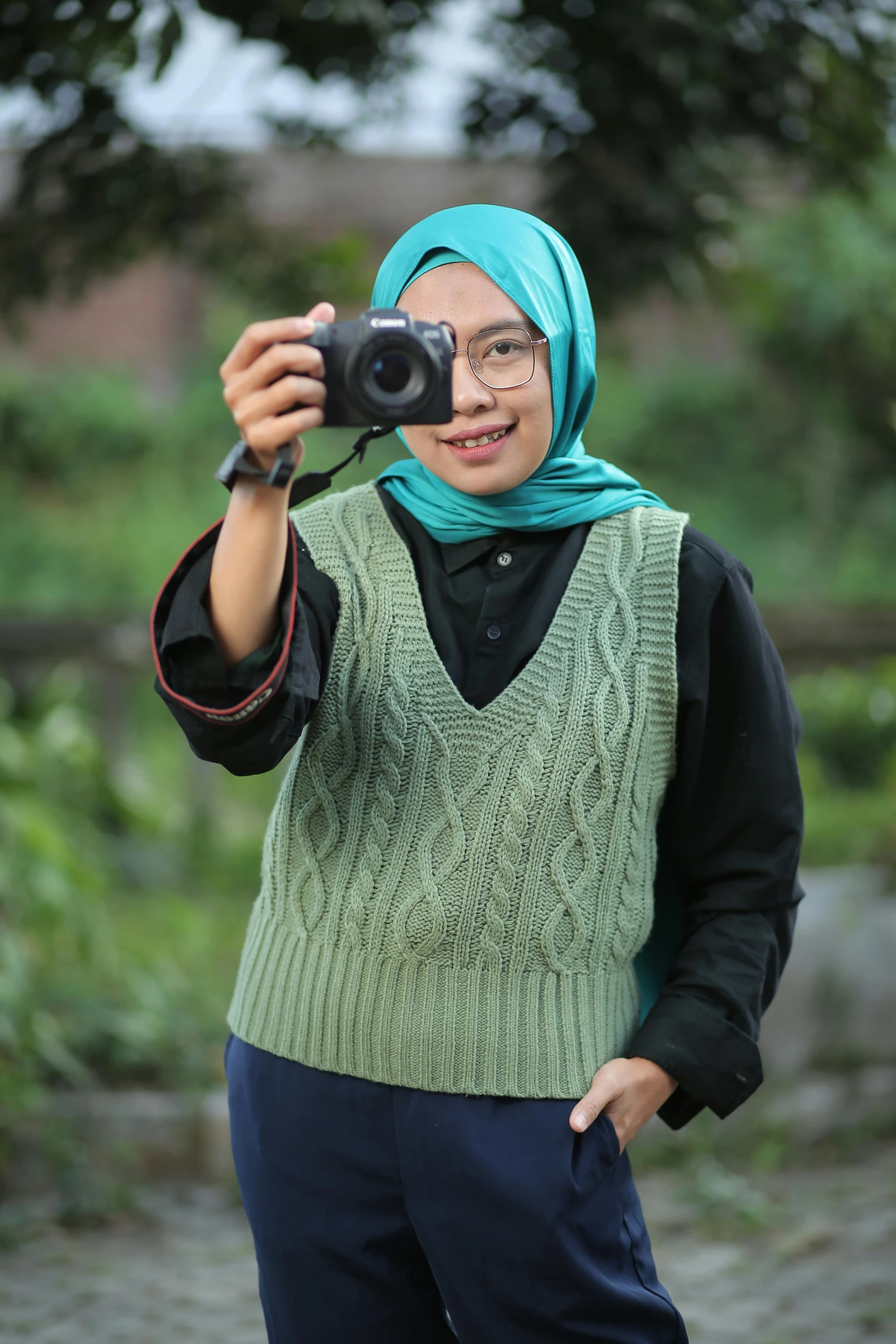 a young woman takes a po while holding a camera