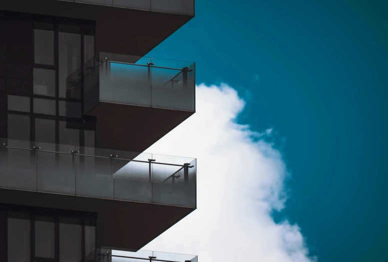 an apartment building that is next to a cloud