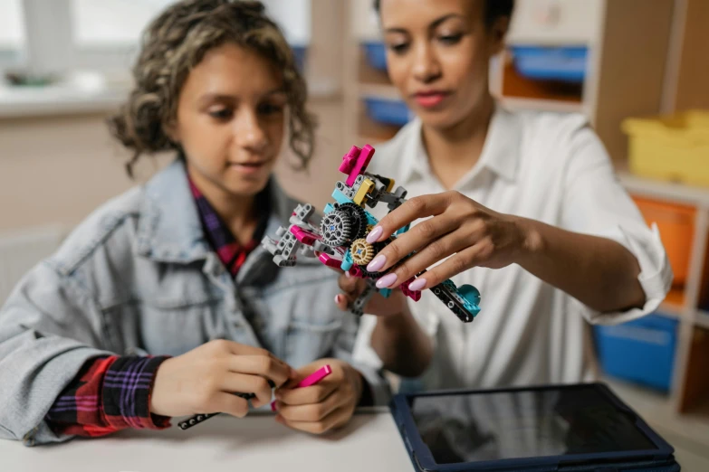 two women are examining a model skeleton with multi - colored toys