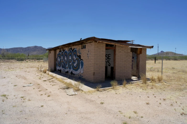 a rusted out out building in the middle of a field