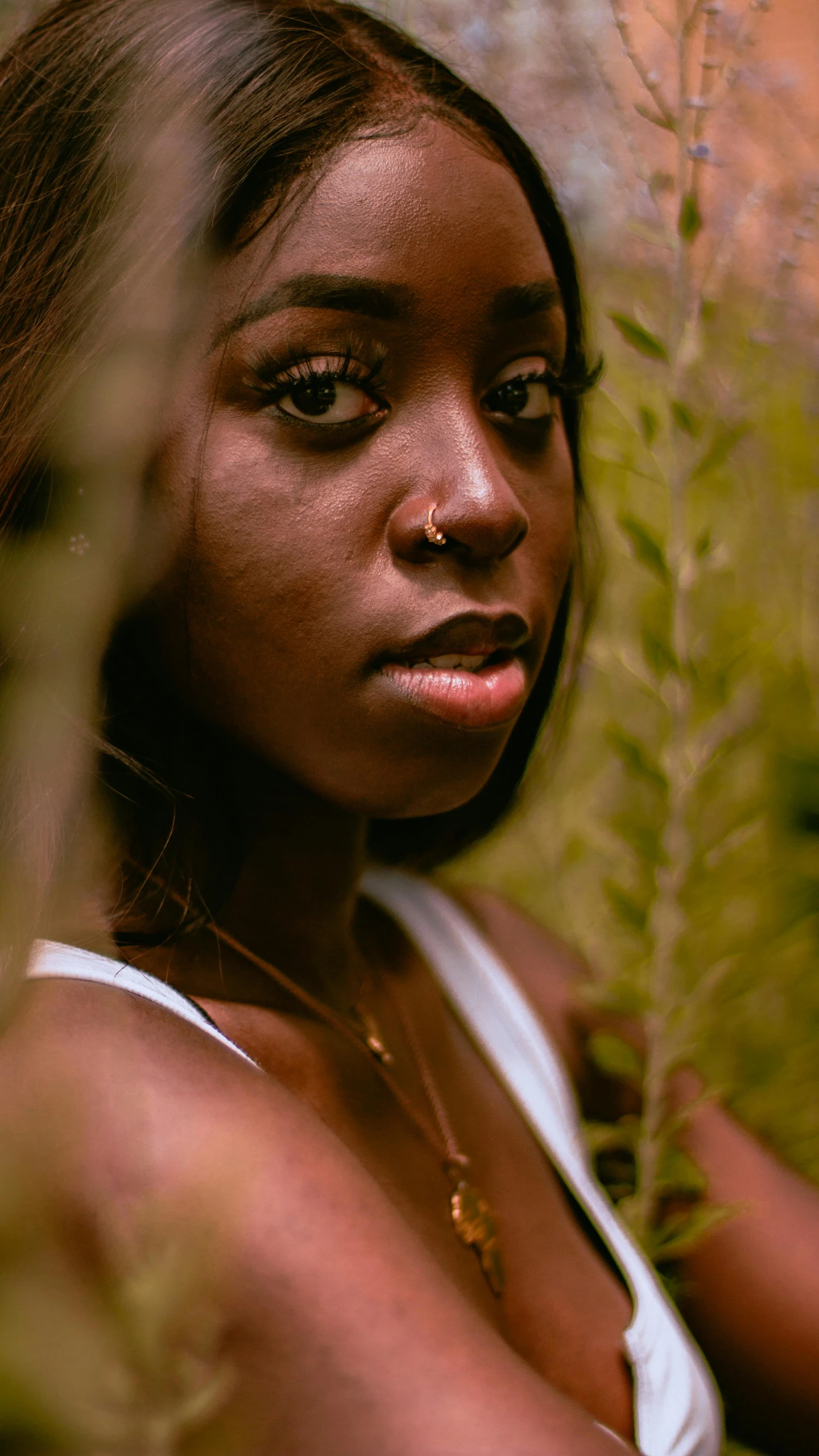 a woman wearing a yellow nose piece with an earring is posed in a pograph