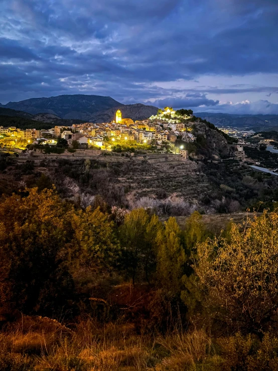 a mountain top town lit up at night