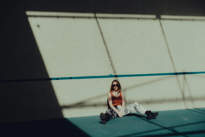 the woman is sitting down with her legs crossed and there are some shadows