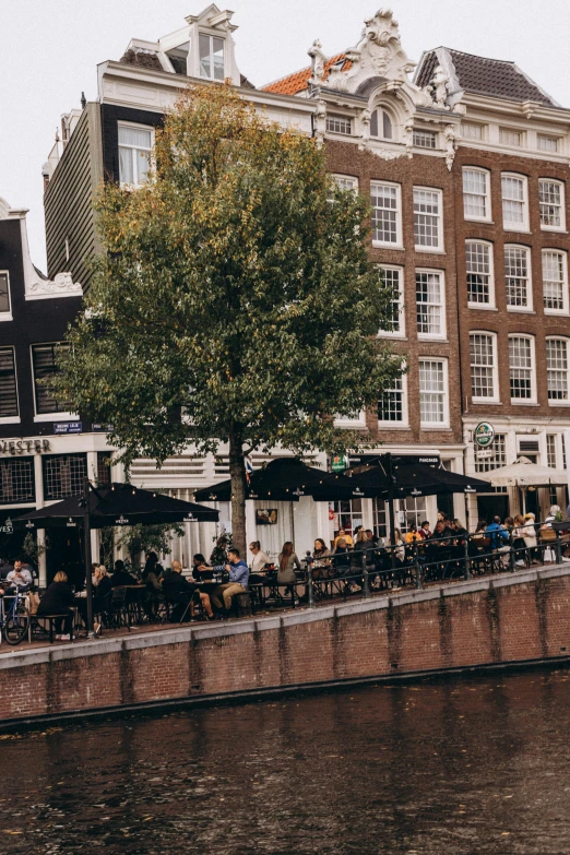 the people are enjoying the sunny afternoon by the river