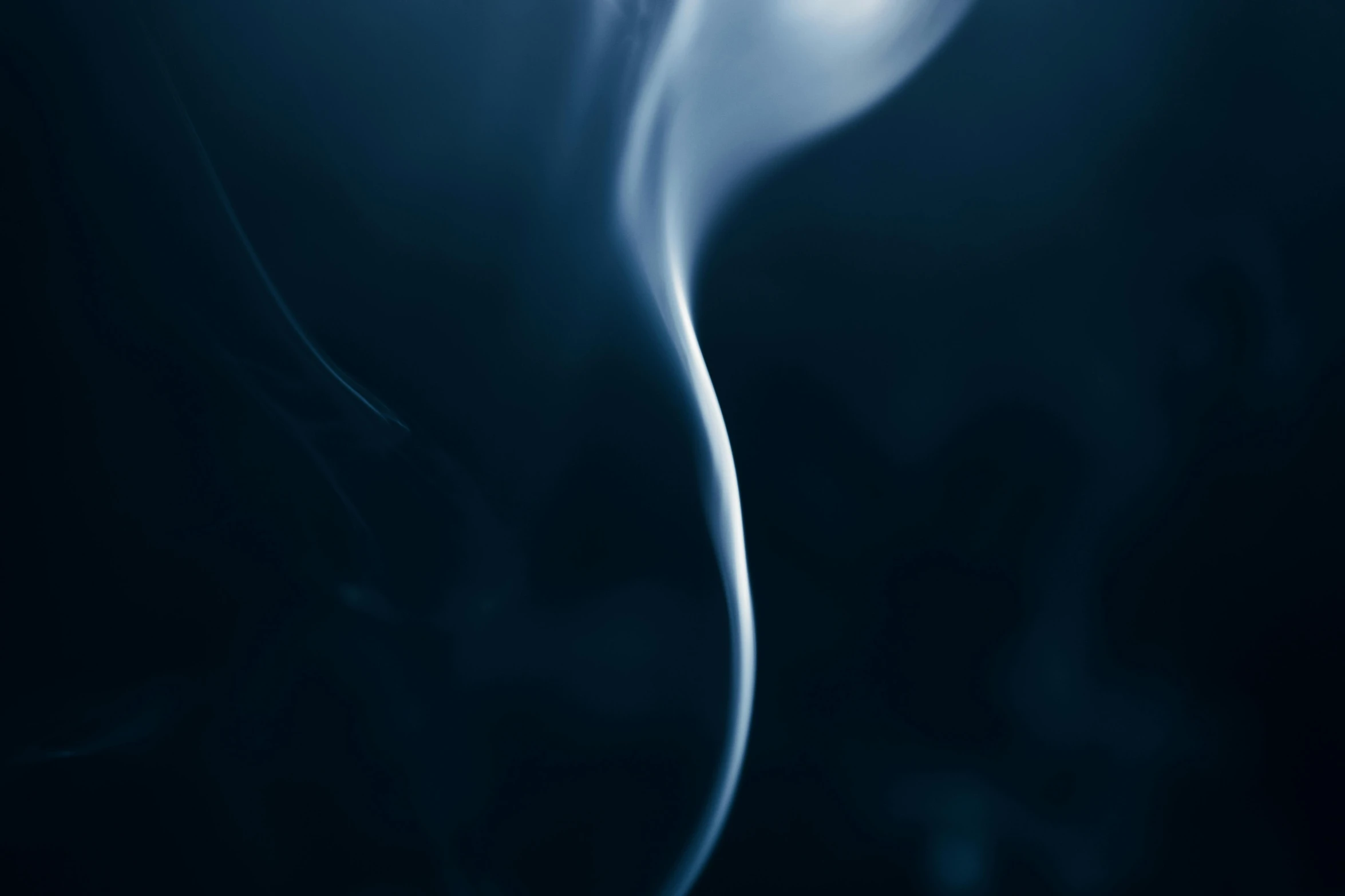 blue smoke swirling across the camera on a dark background