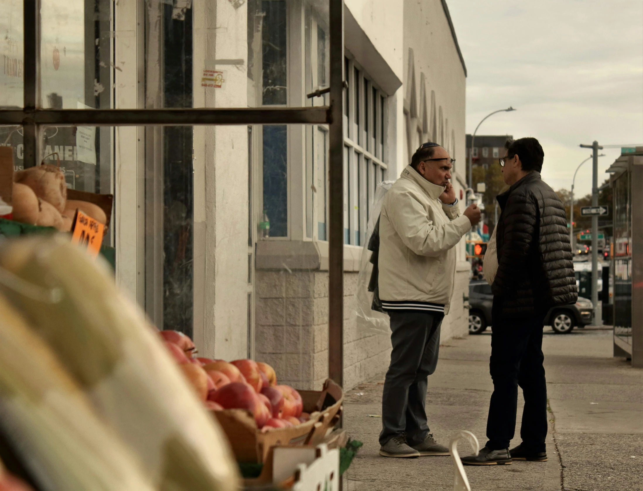 two men standing near each other talking on cell phones