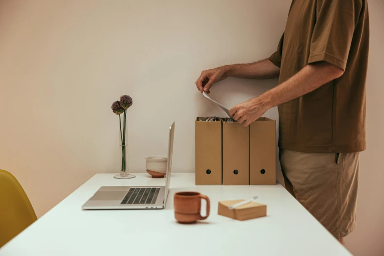 the man is using the knife to cut up the package on the table