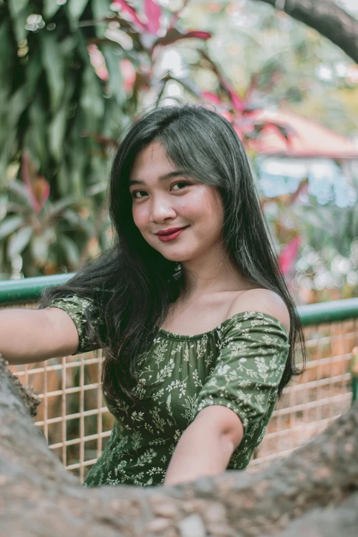 the woman poses for the picture near a tree