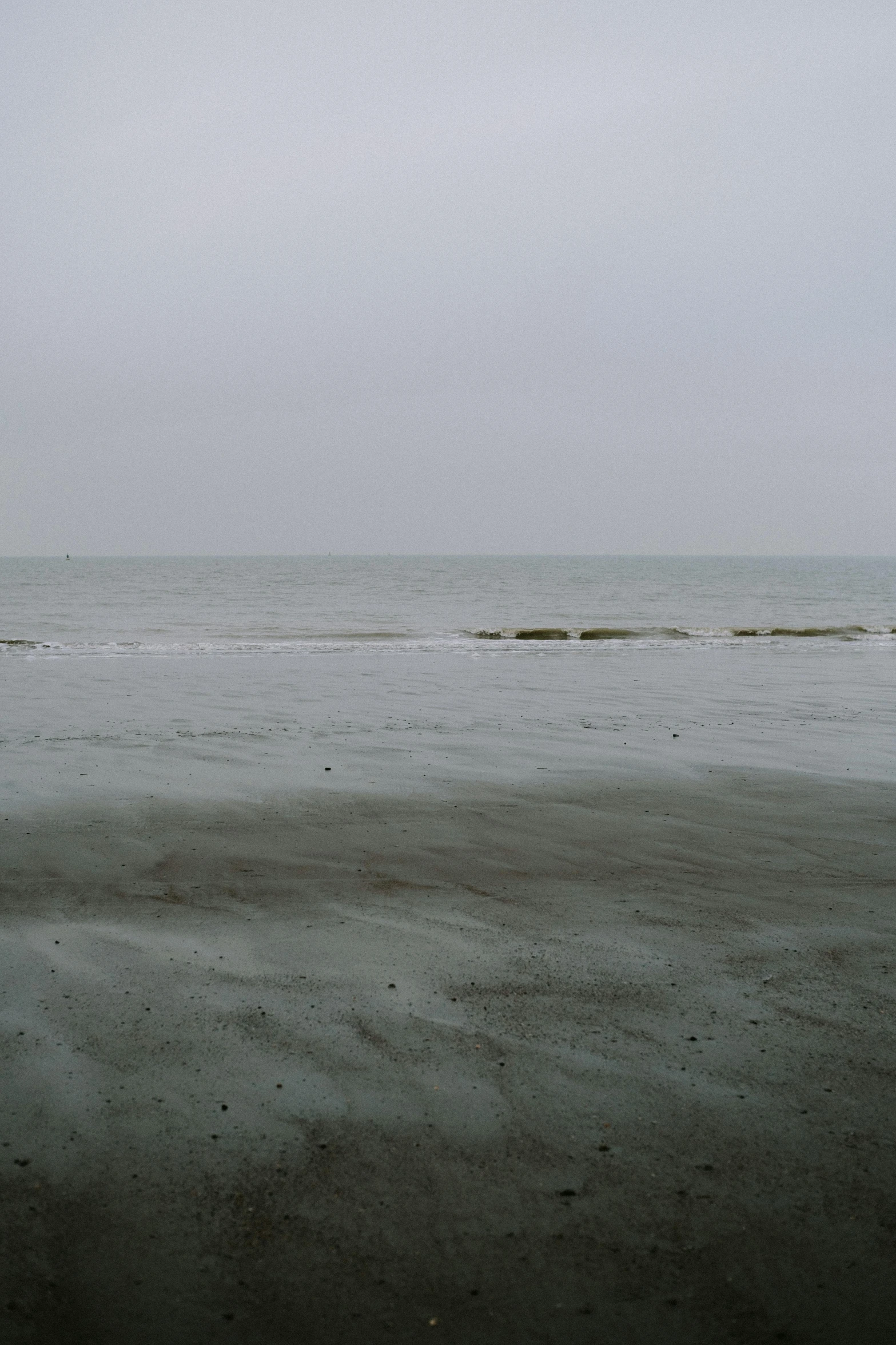 the beach is completely deserted and a surfboard is in the water