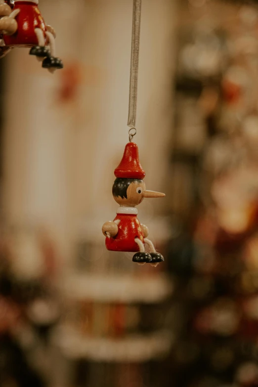 christmas ornaments hanging from strings with two elf characters on them