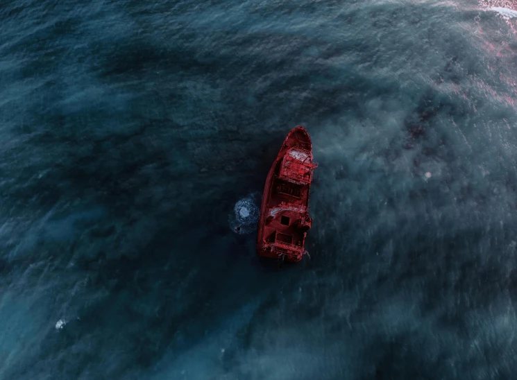 an aerial view of a boat out in the ocean