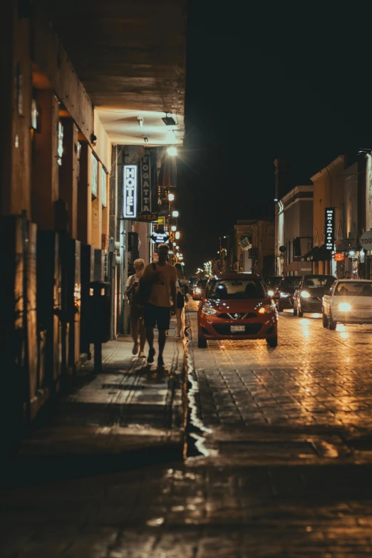 cars and people are in the dark on a rainy street