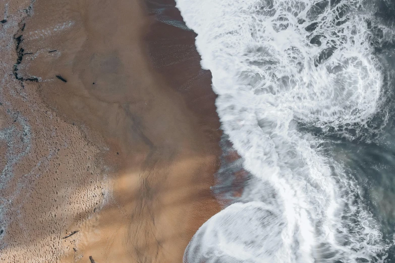 an aerial view of a sandy beach next to the ocean