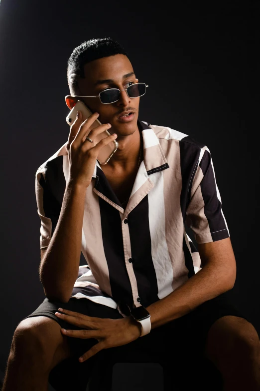 a man in sunglasses sits with his hands on his face