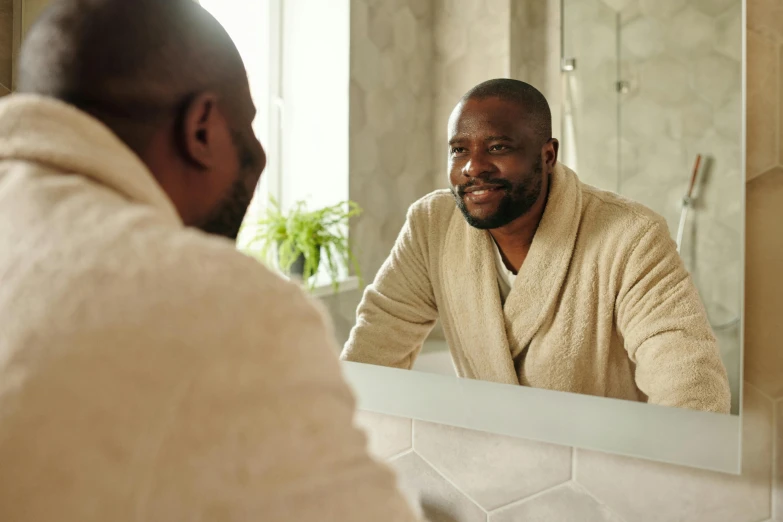 a man with a robe is looking in the mirror