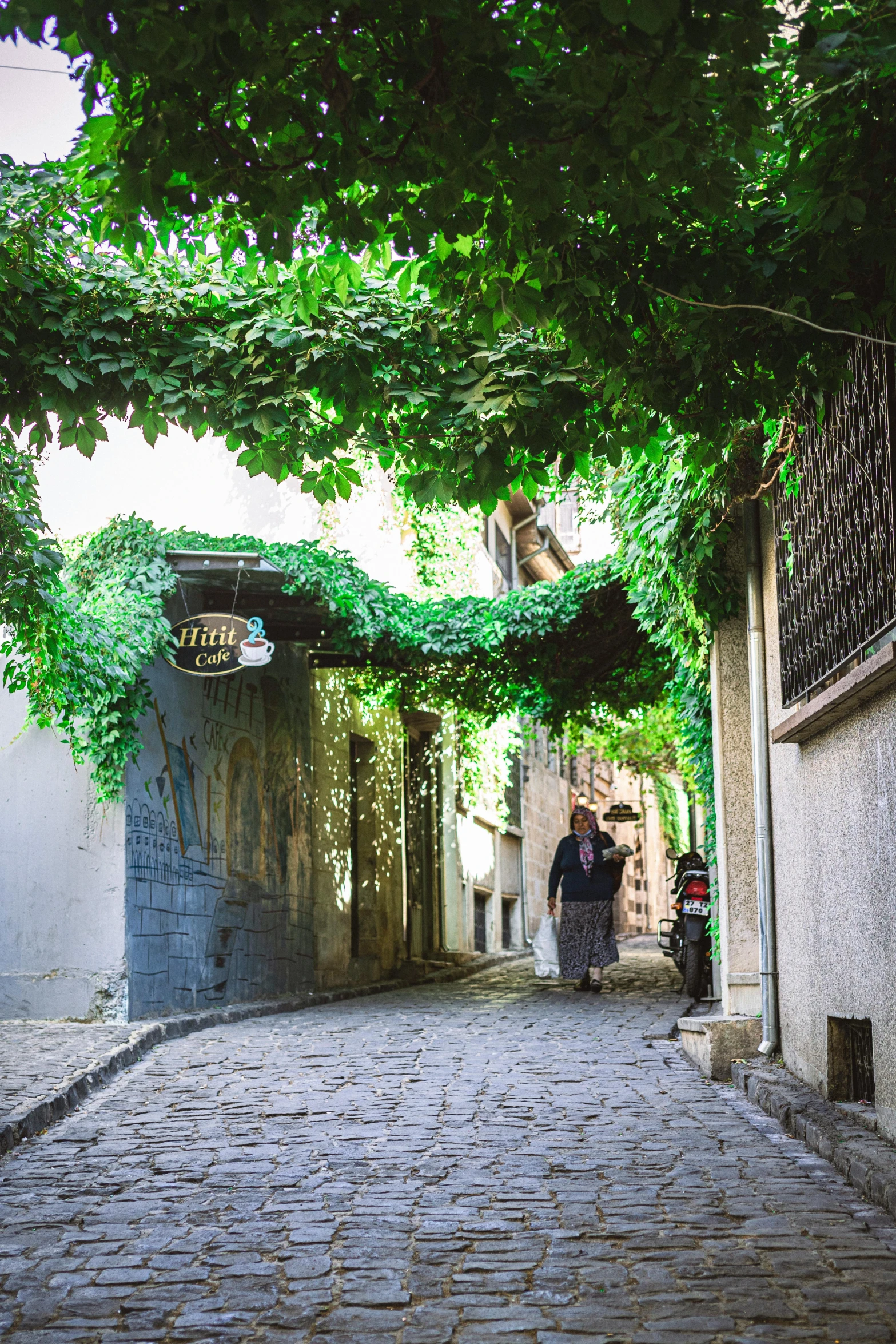 a group of people walking down a cobblestone alleyway