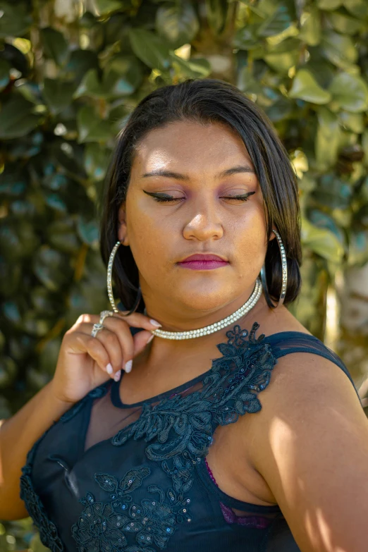 woman in black dress posing and wearing earrings