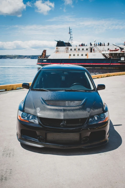 a sports car is parked in front of a ferry