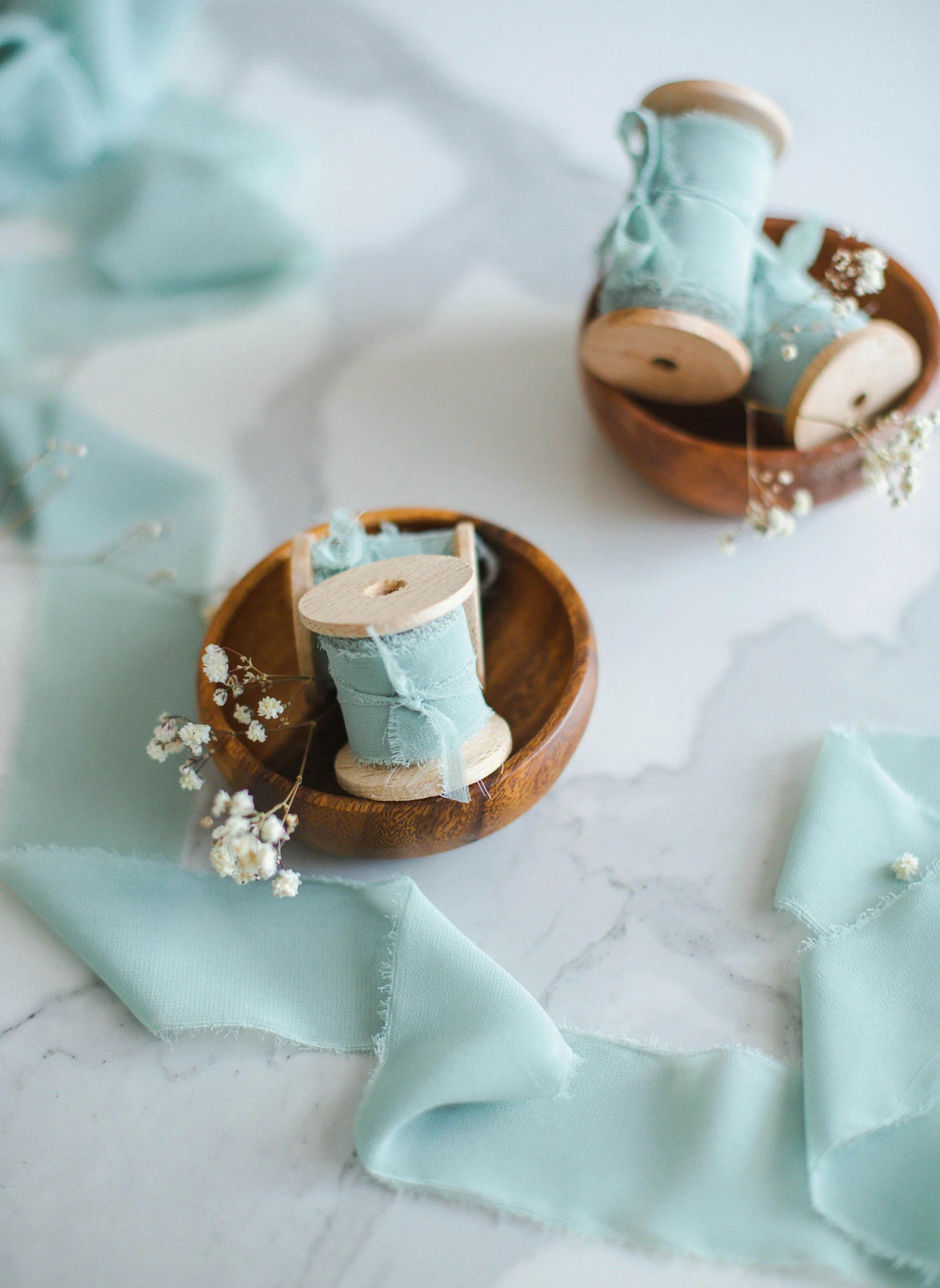 this picture is of a pair of baby blue shoes and a spool of thread