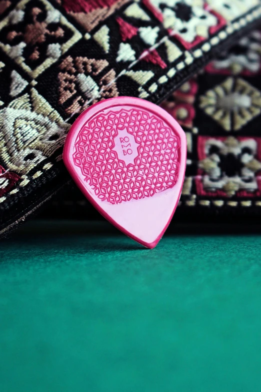 there is a pink plastic pick resting on a rug